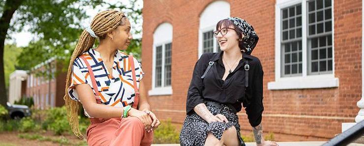 two students smiling at each other in profile