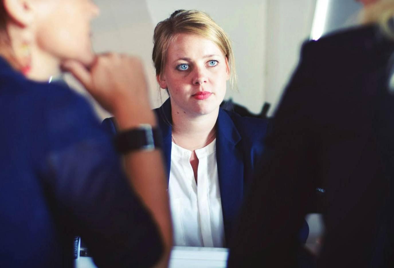 young women at table facing two professionals